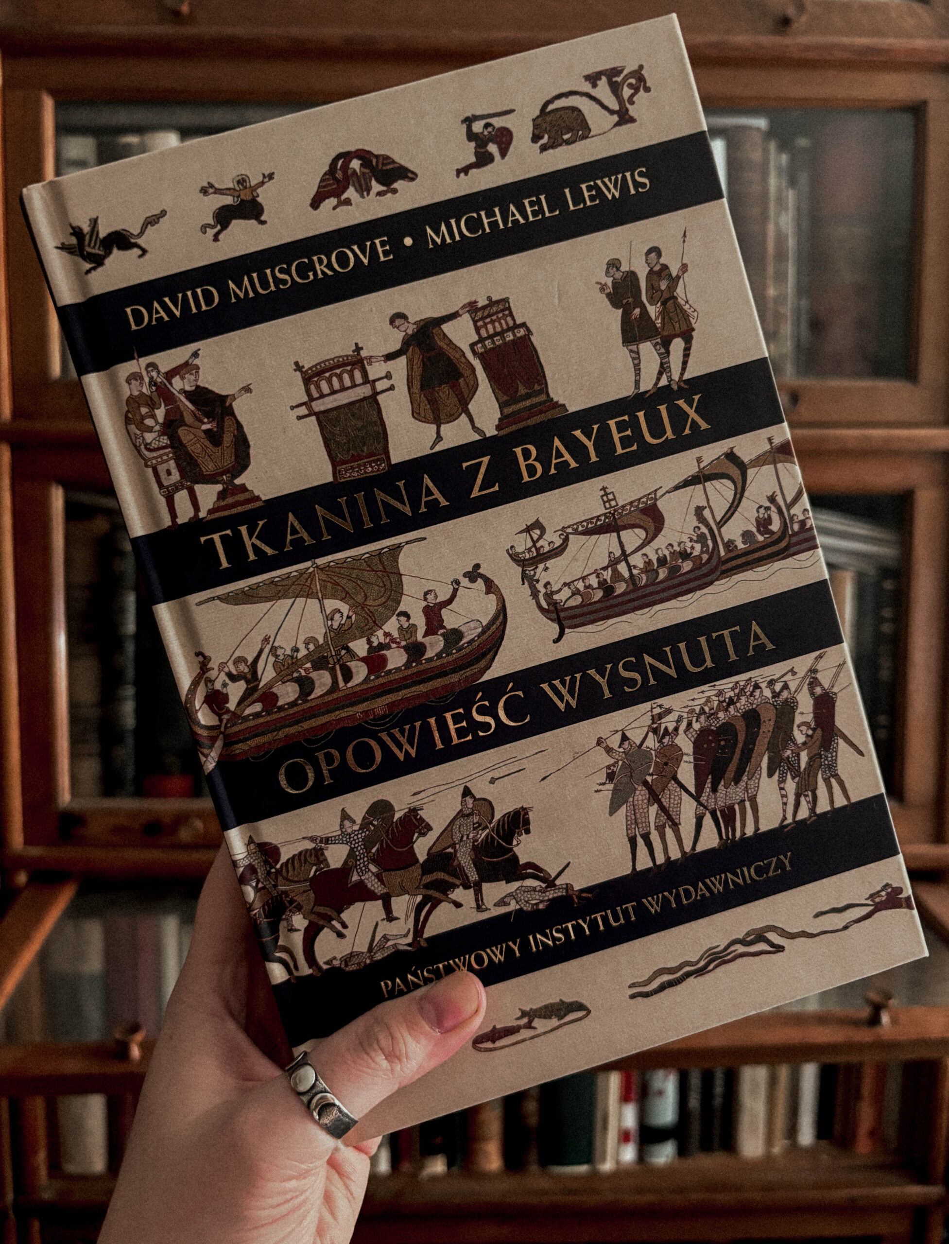 Książka „Tkanina z Bayeux. Opowieść wysnuta” autorstwa Davida Musgrove’a i Michaela Lewisa to publikacja wydana przez Państwowy Instytut Wydawniczy. Pozycja ta koncentruje się na jednym z najważniejszych zabytków średniowiecznej Europy – Tkaninie z Bayeux – przedstawiając fascynującą historię jej powstania oraz interpretując jej szczegółowe sceny. Bogato ilustrowana i wydana w estetycznej oprawie, książka będzie idealna dla miłośników historii, sztuki i kultury średniowiecza. Szukasz ciekawego opracowania o Tkaninie z Bayeux? Sprawdź tę publikację!